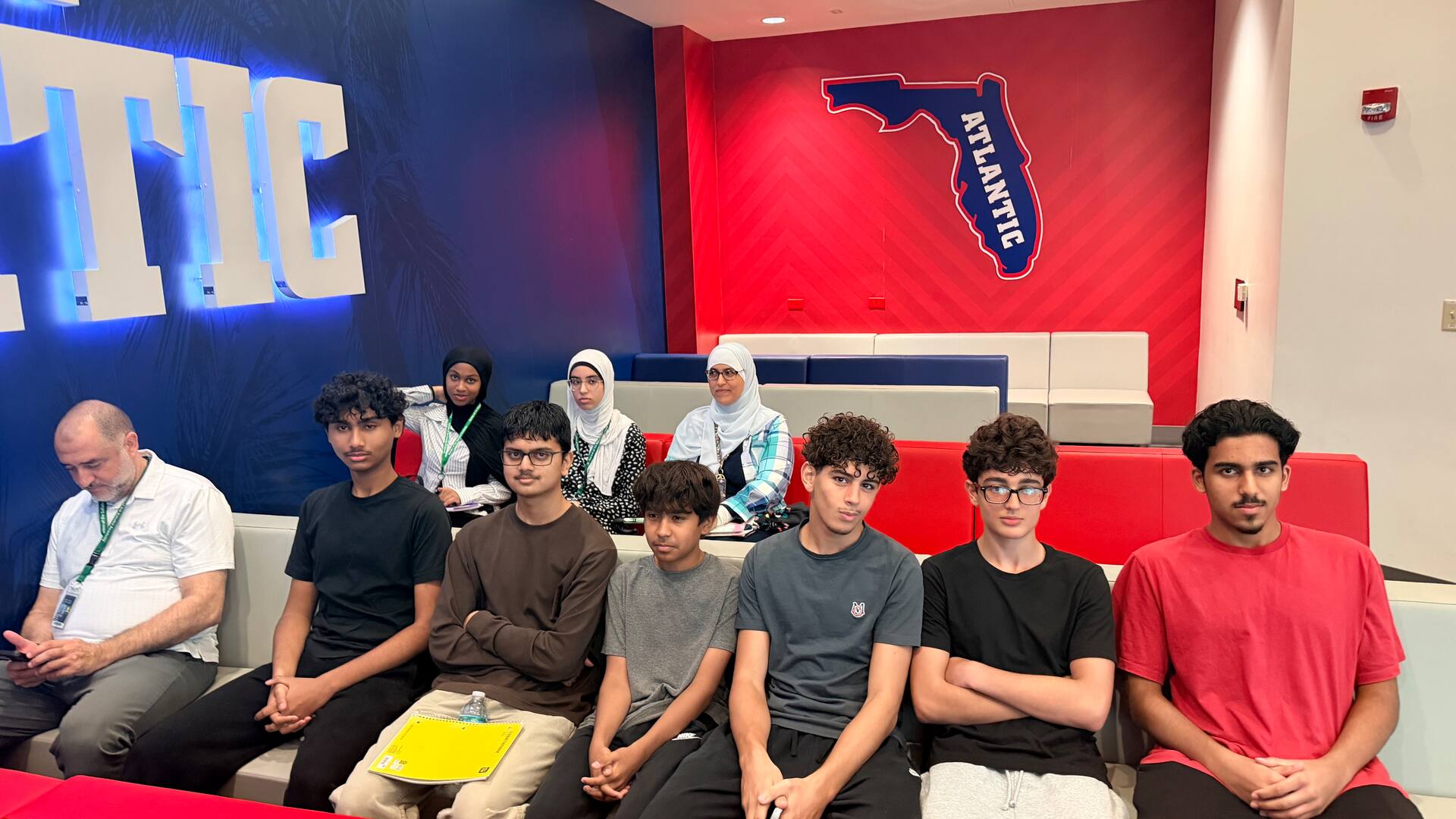 Students seated beneath the lit Florida Atlantic sign