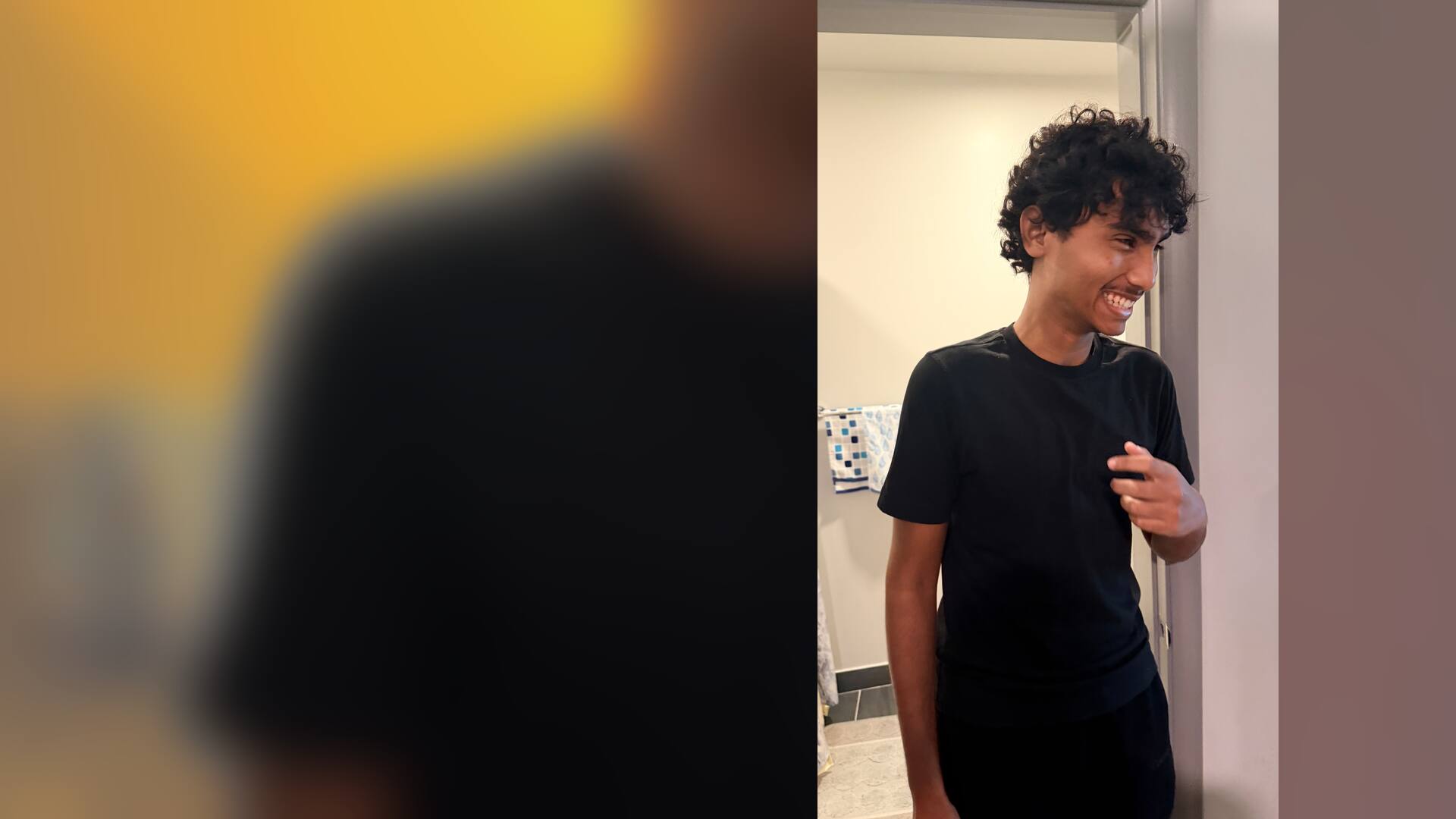 A student grinning in a dorm doorway
