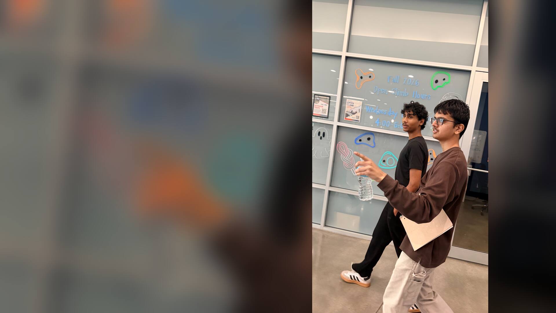A student pointing out the climbing wall schedule