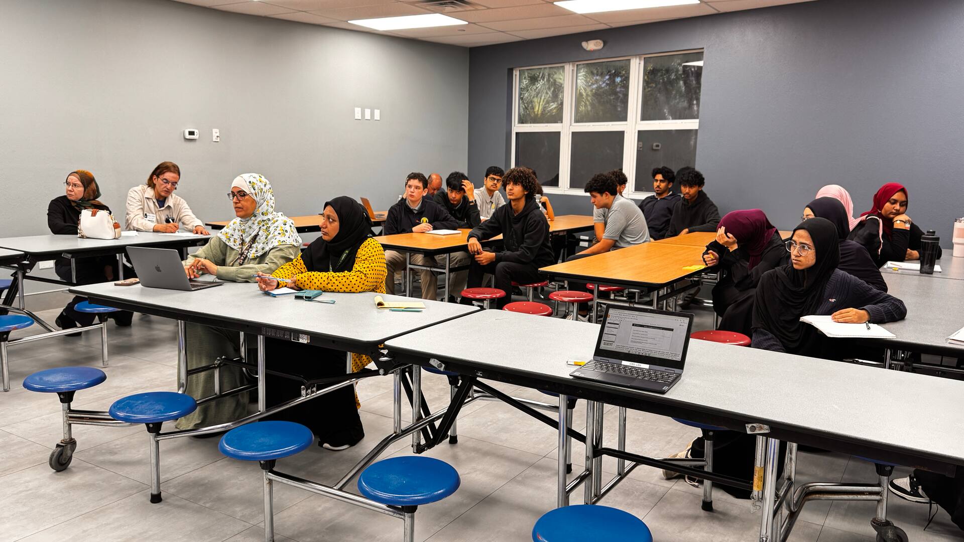Families and students seated across the room, ready for the presentation