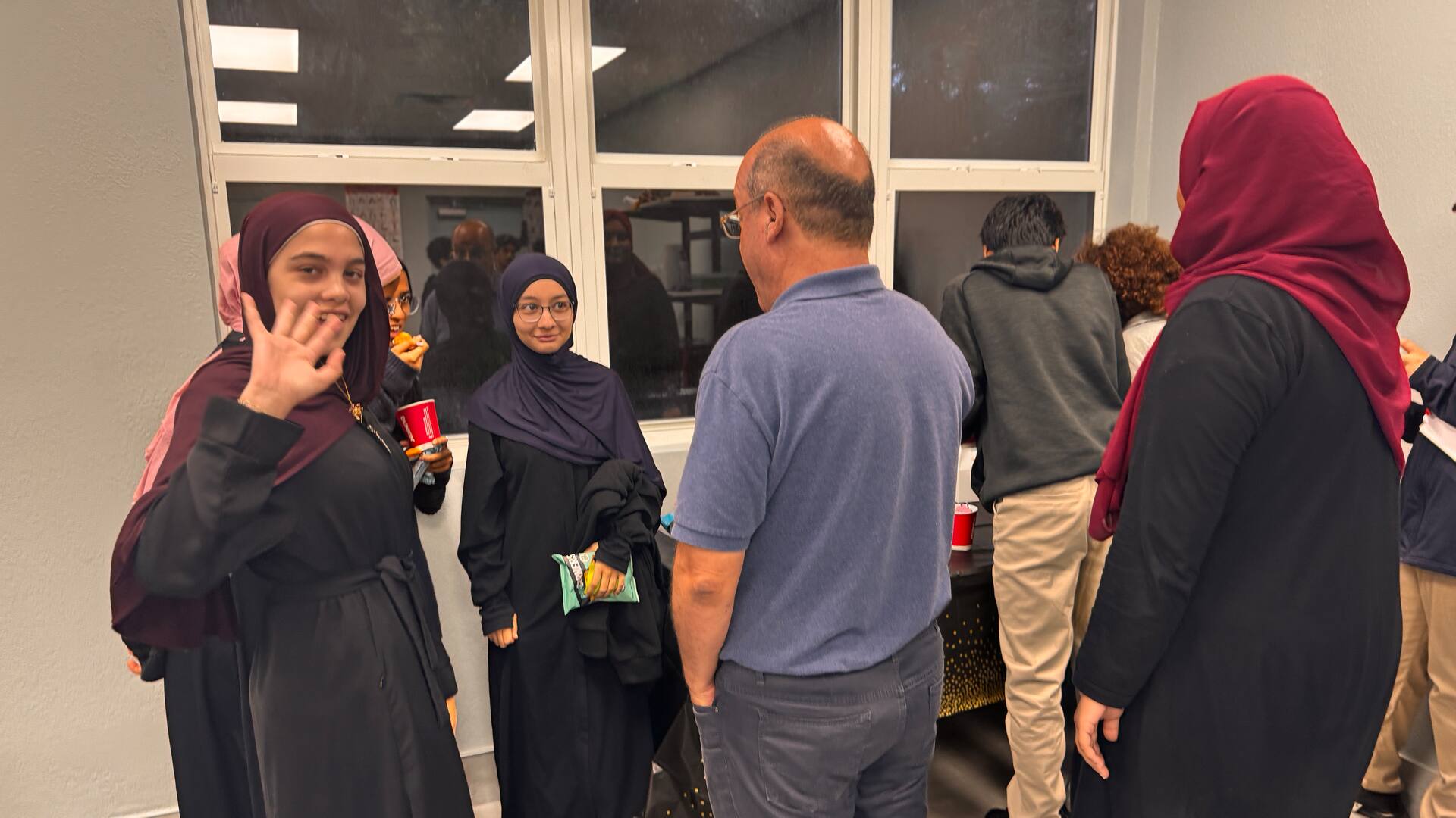 A student waving hello during the social time after the talk
