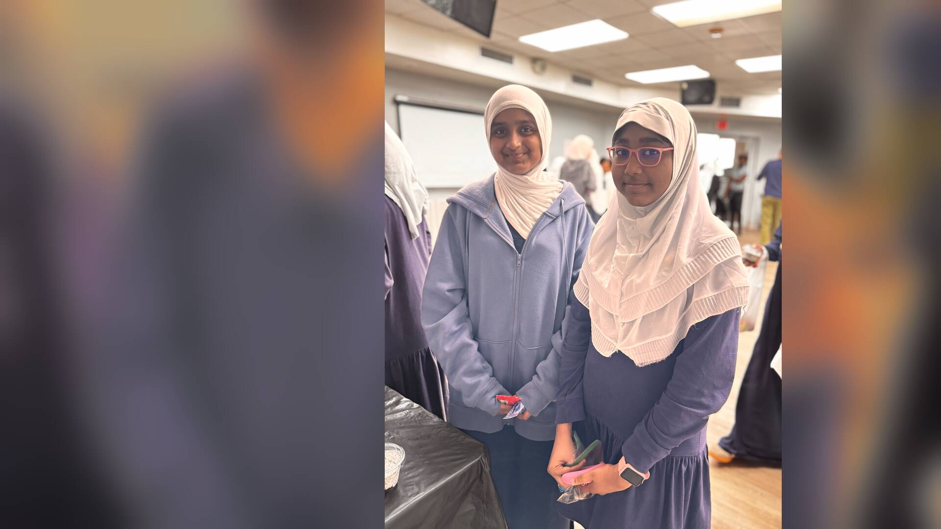 Two students smile for the camera with their treats in hand