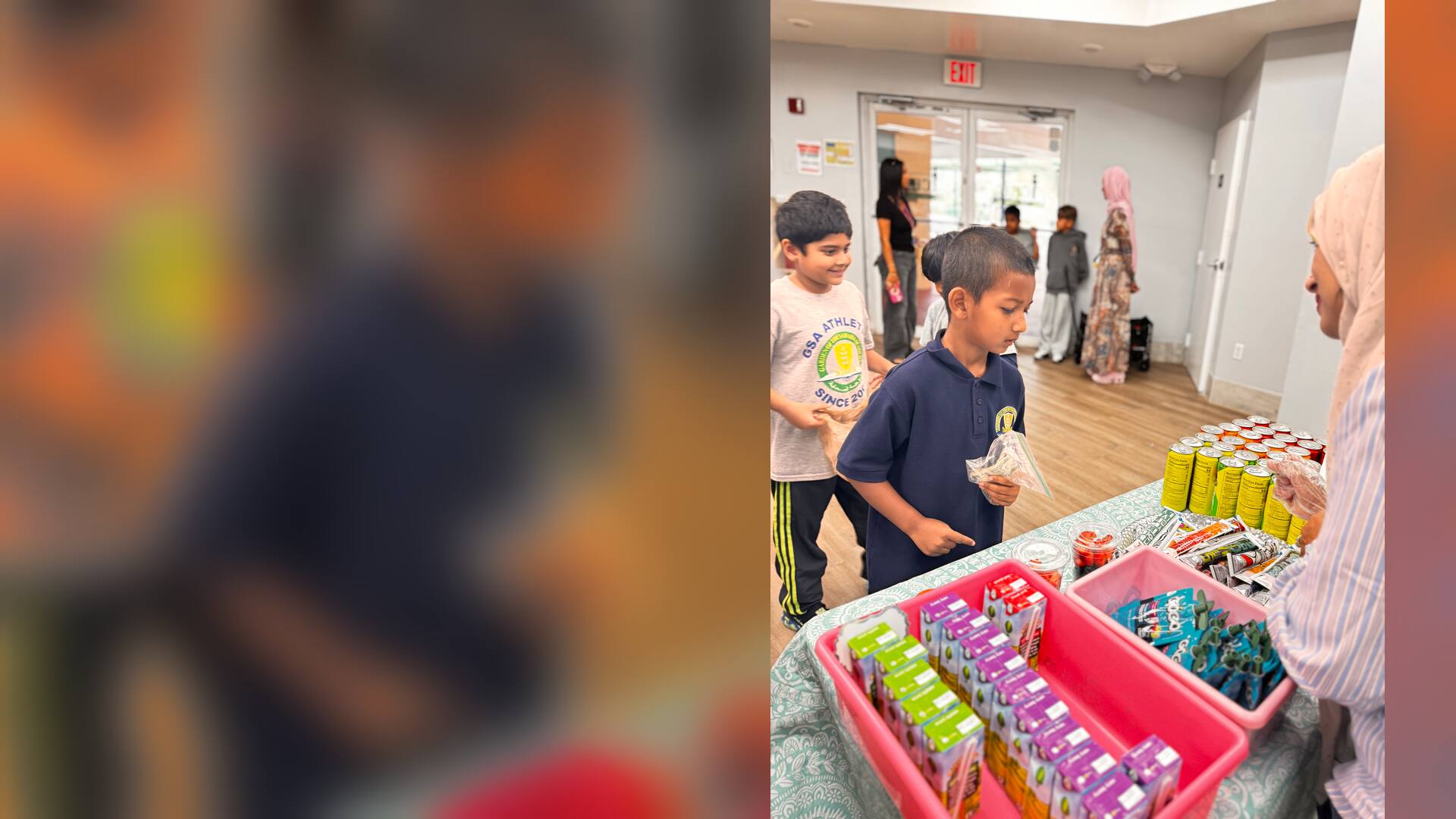 Young students pick out juice boxes and snacks at the drinks table