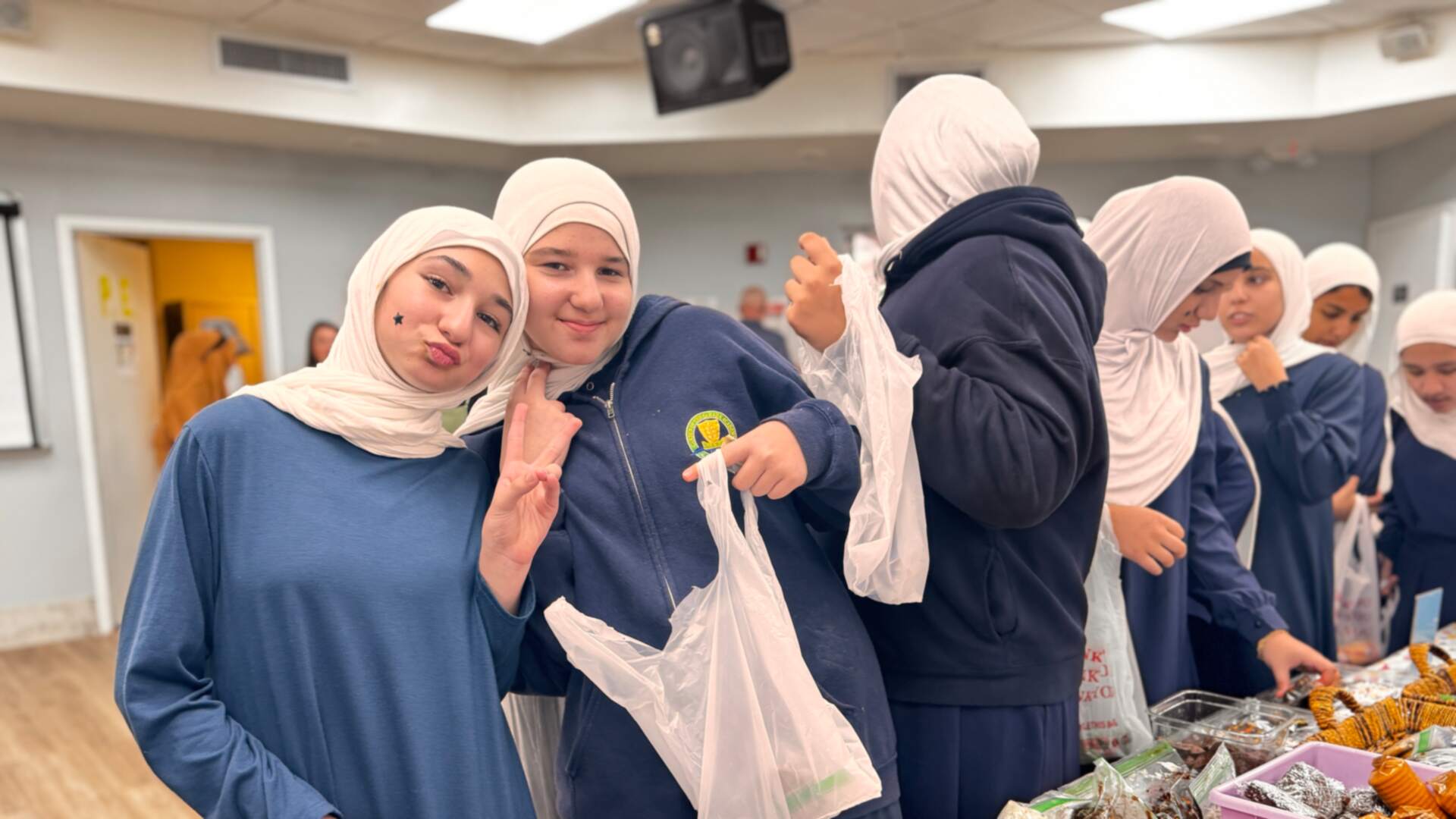 Older students pose with peace signs and their shopping bags