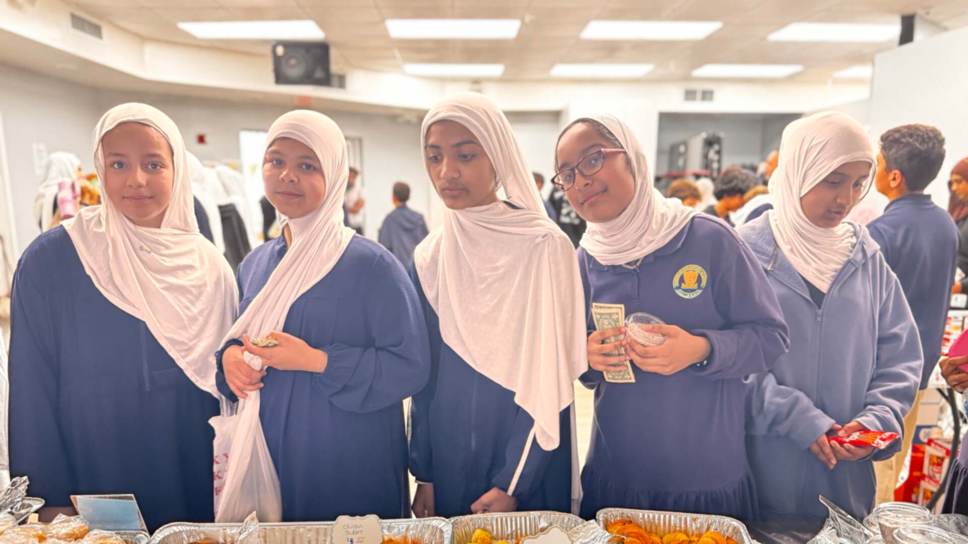 Older students holding cash smile while waiting at the savory table