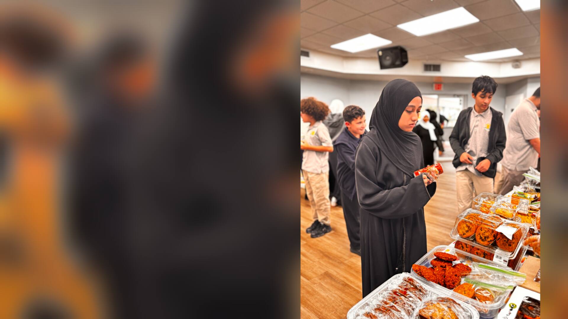 An older student checks out a snack beside trays of cookies
