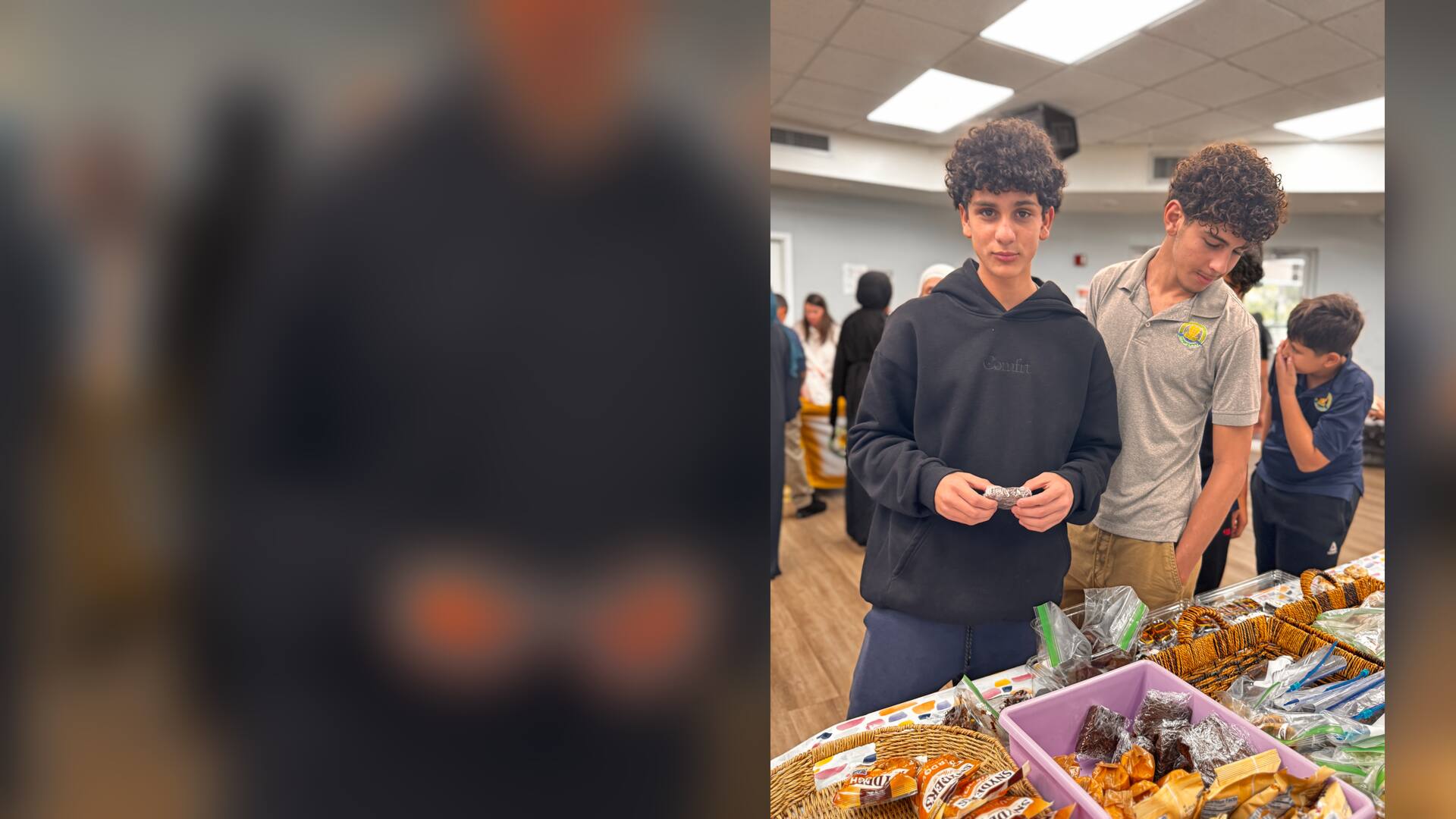 An older student holds a brownie at the snack baskets