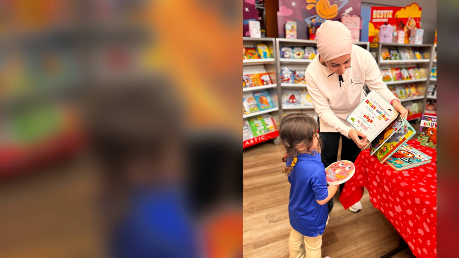A teacher showing a picture book to a young student
