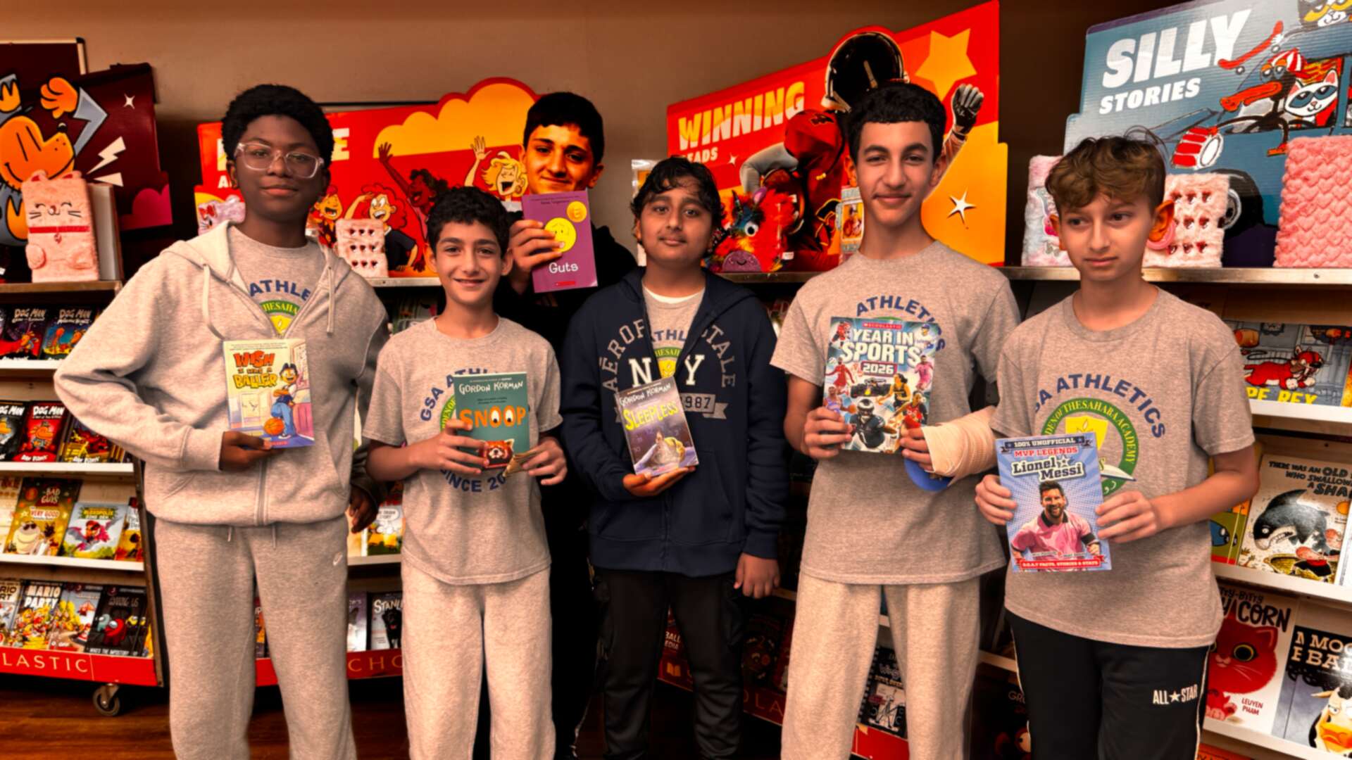 A group of students holding up their chosen books