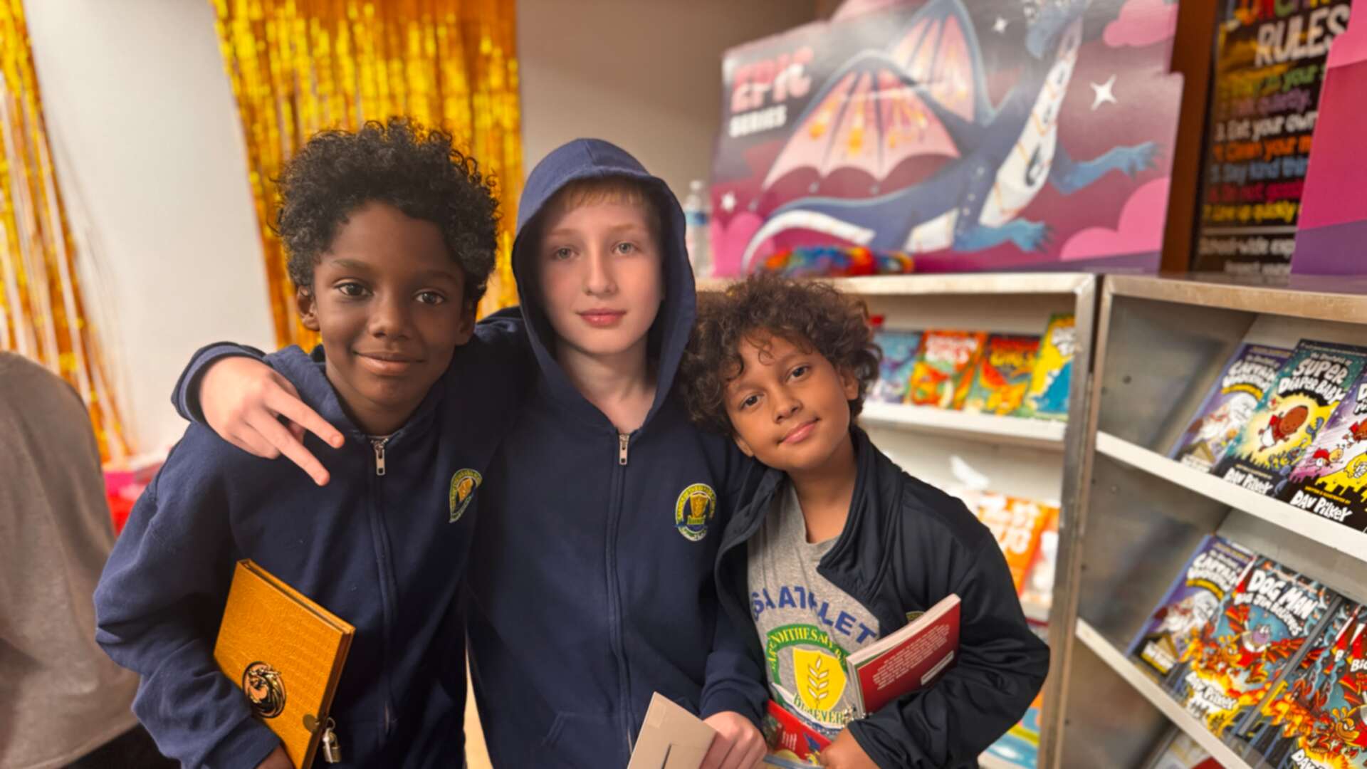 Three friends posing with their book fair finds