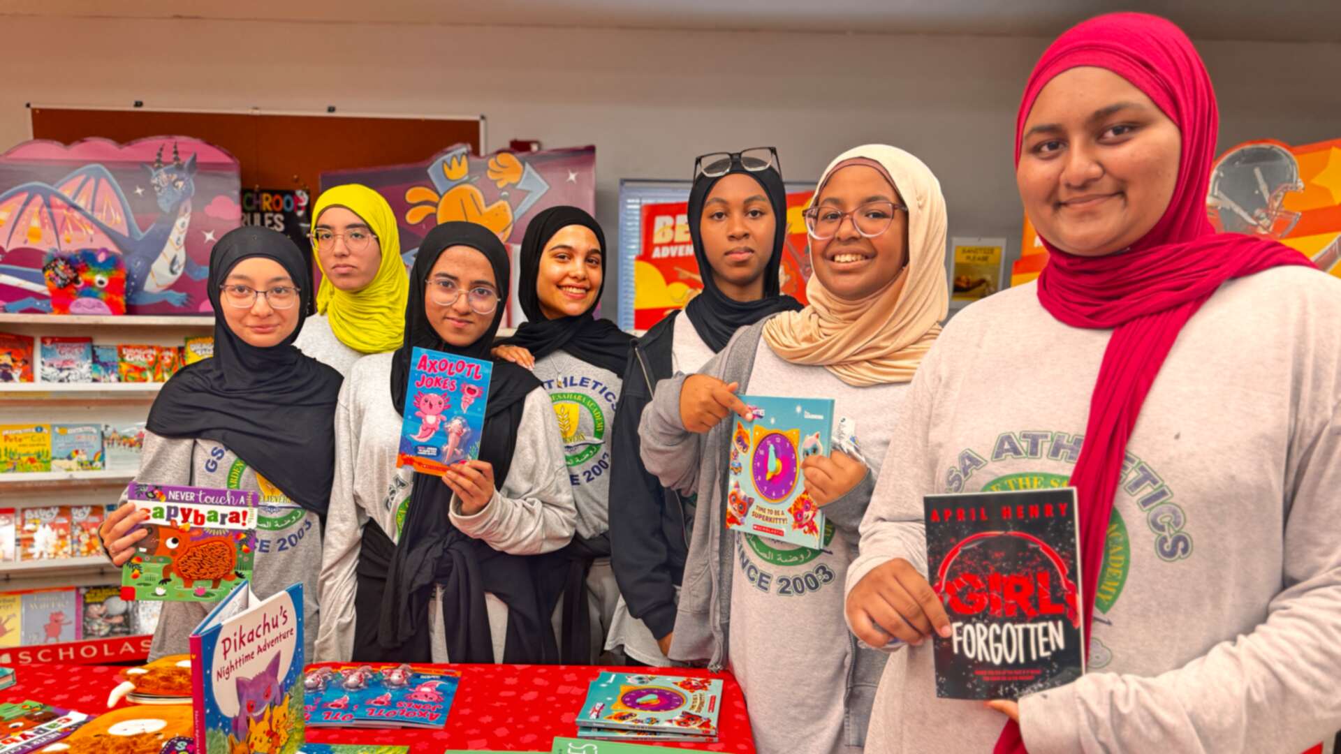 A group of students showing their books at the fair table