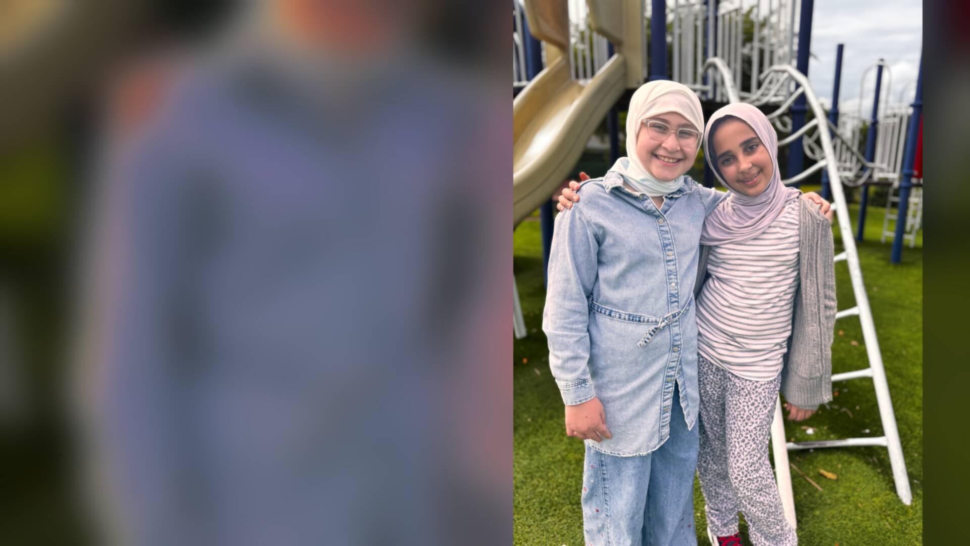 Two friends in denim and stripes share a hug by the slide