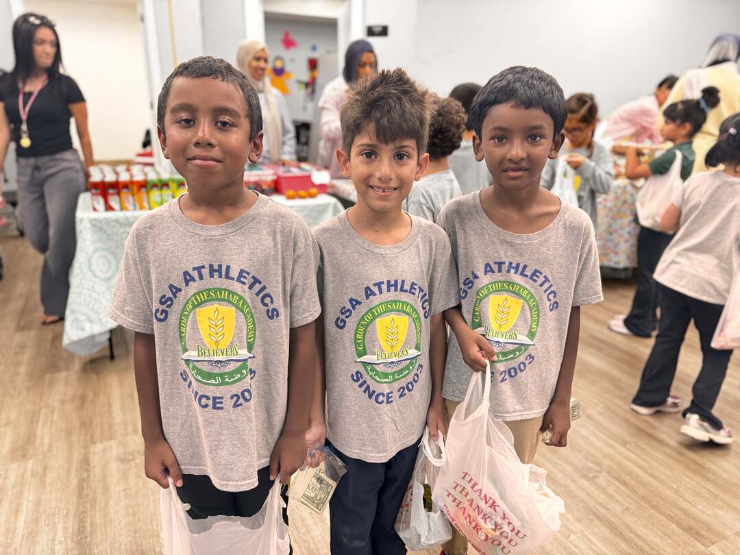 Three students in GSA Athletics shirts stand side by side with their bake sale bags