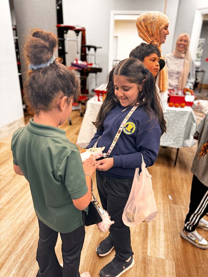 Two students in uniform chat as they count their money