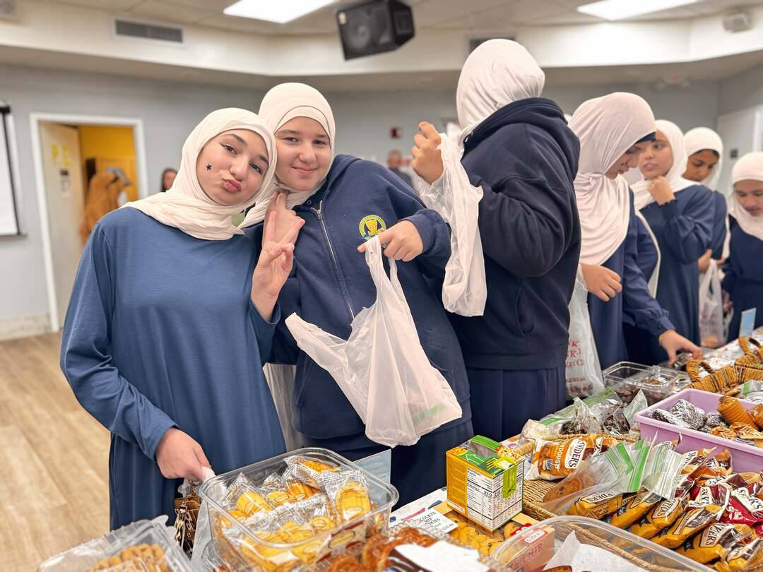 Older students pose with peace signs and their shopping bags