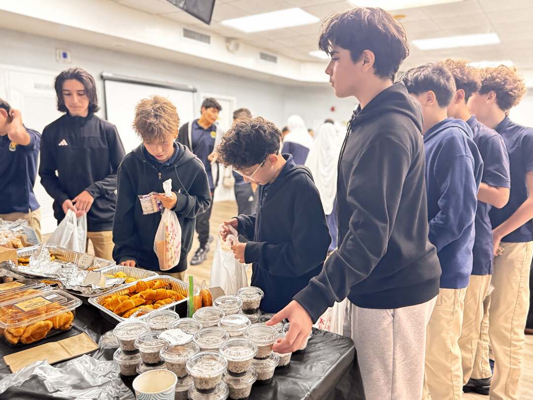 Older students gather around cups of pudding and pastries