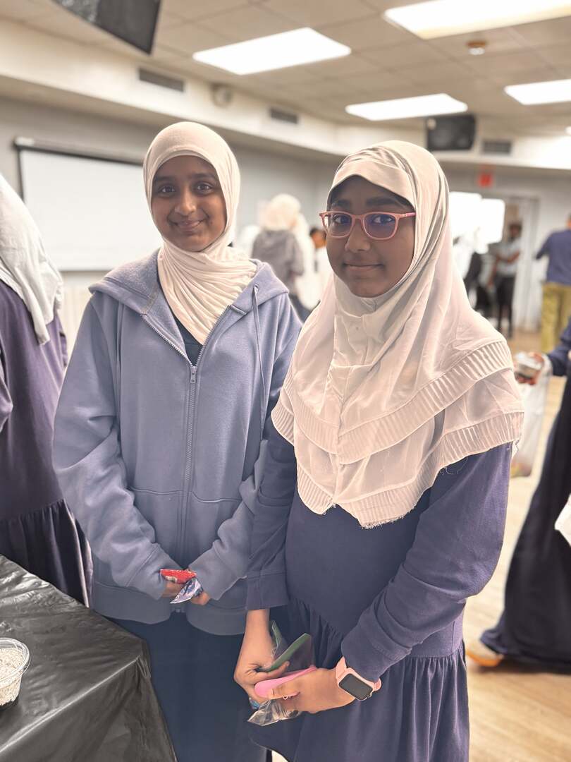 Two students smile for the camera with their treats in hand