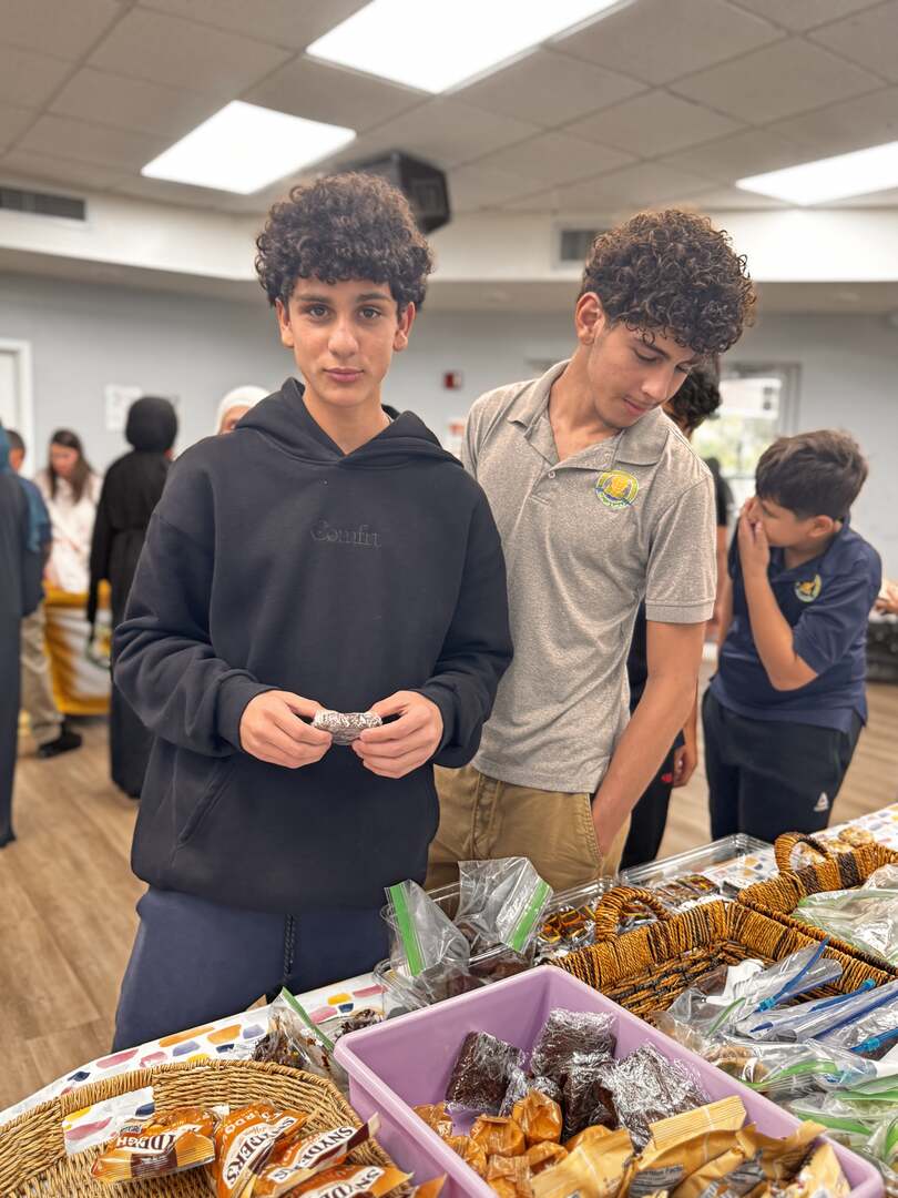 An older student holds a brownie at the snack baskets