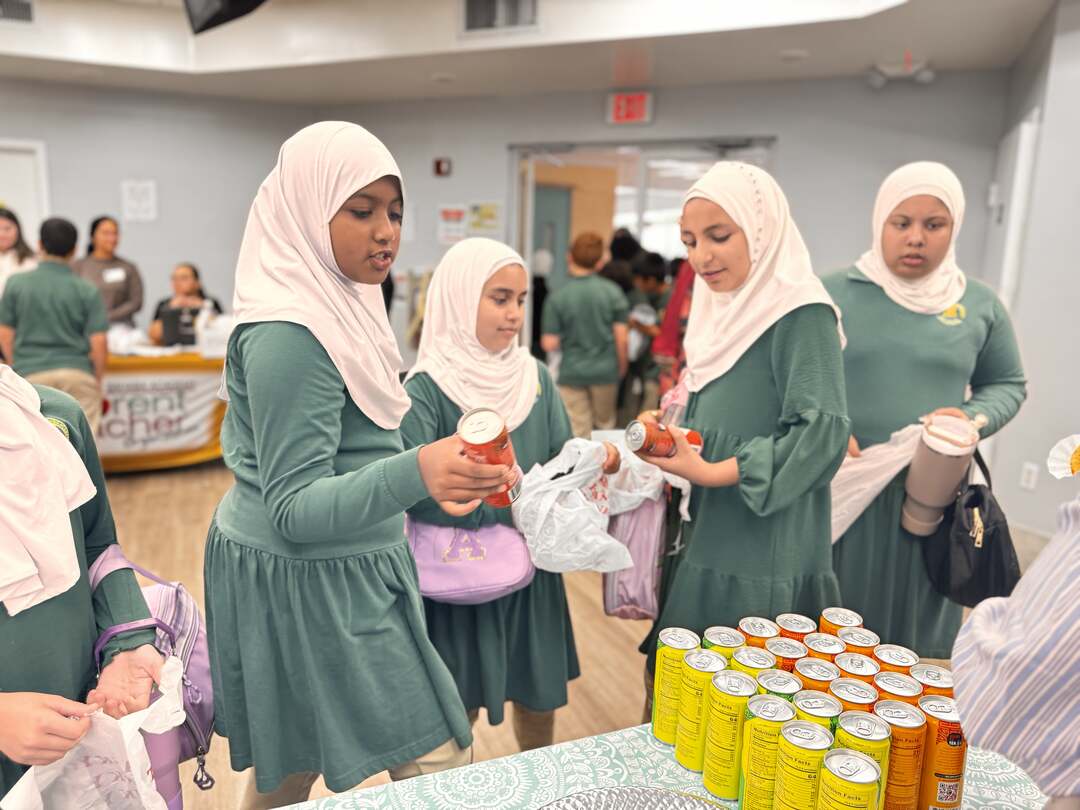 Friends pick out canned drinks to go with their treats