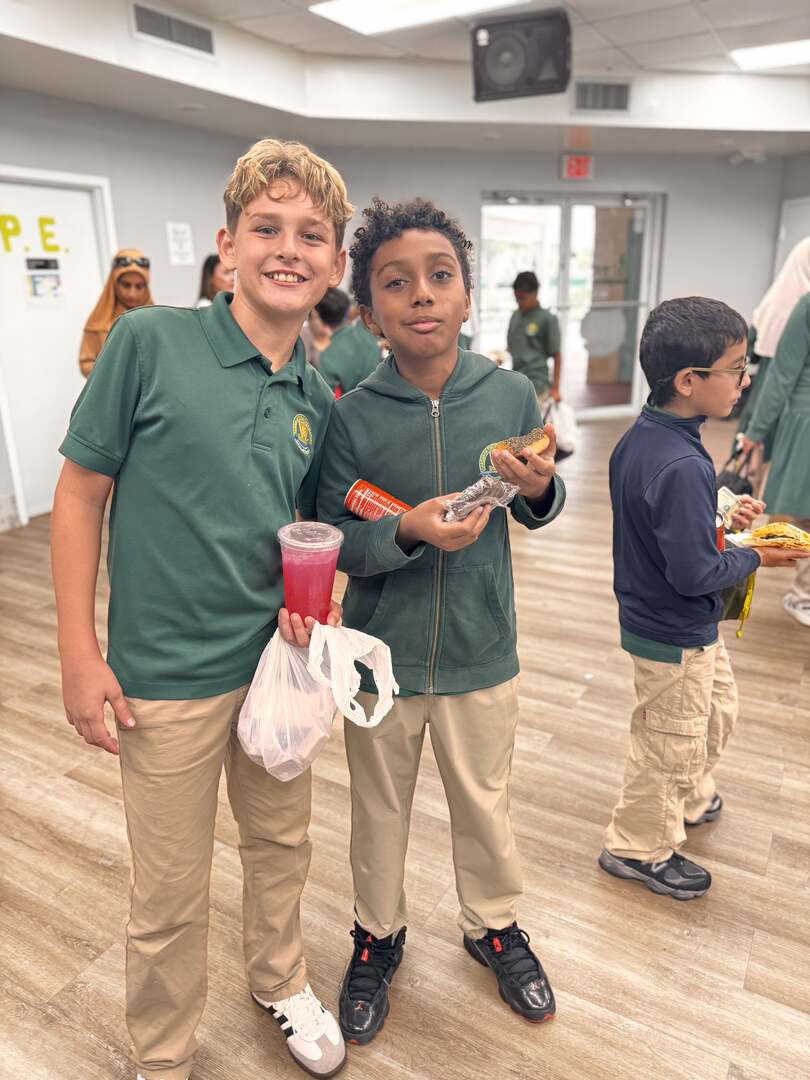 Two friends show off a pink drink and a snack from the sale