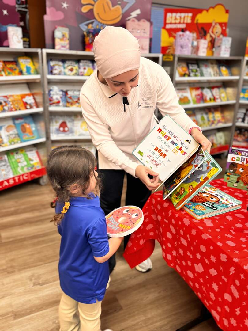 A teacher showing a picture book to a young student