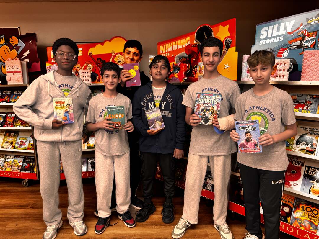 A group of students holding up their chosen books