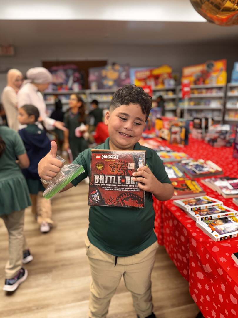 A student giving a thumbs-up with a new activity book