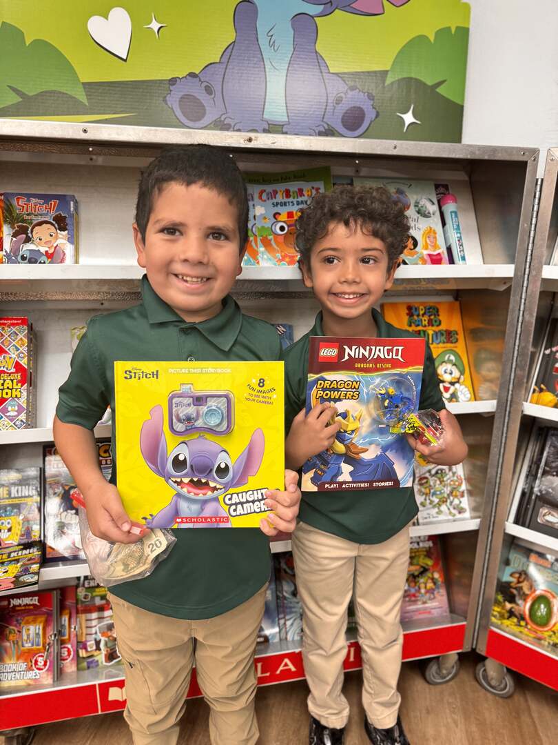Two smiling students showing their new books
