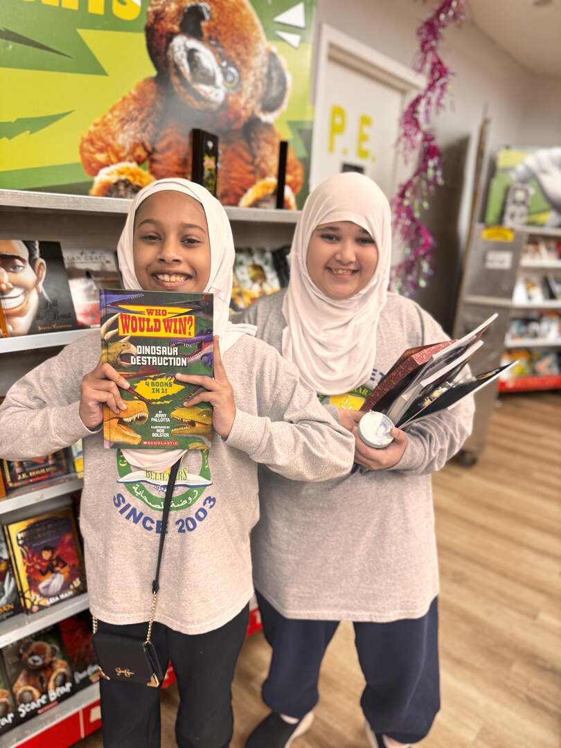 Two students showing off the books they picked