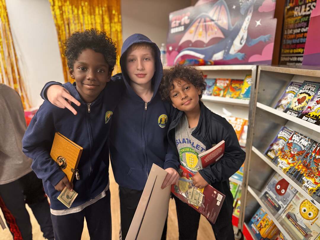 Three friends posing with their book fair finds