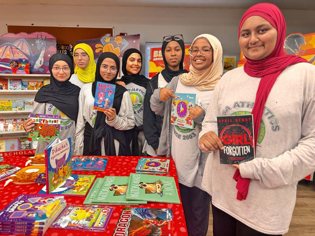 A group of students showing their books at the fair table