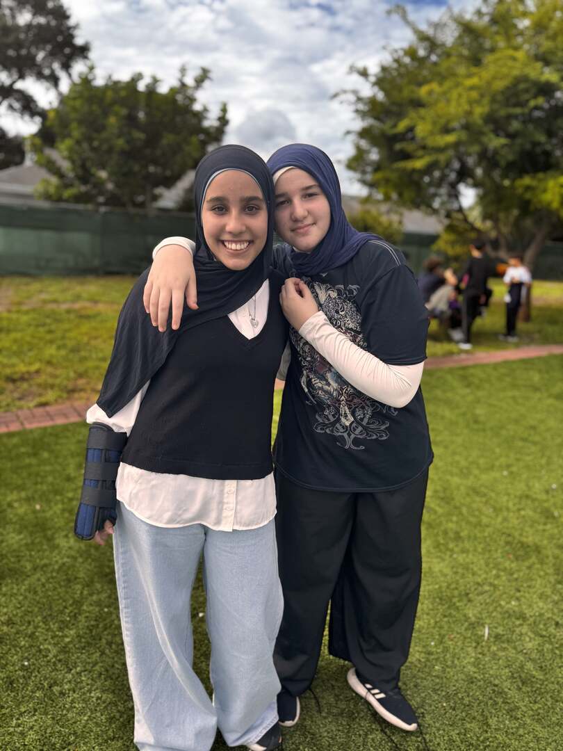 Two friends share a big hug and bright smiles on the field