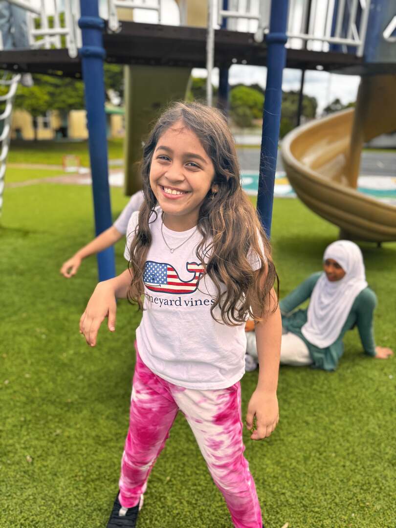 A beaming smile and tie-dye pink pants at the playground