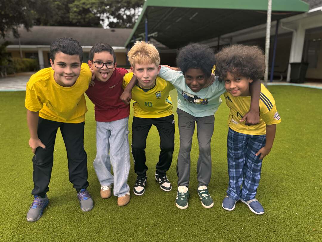 Buddies in sunny yellows, maroon and plaid link arms on the field for Dress Down Day