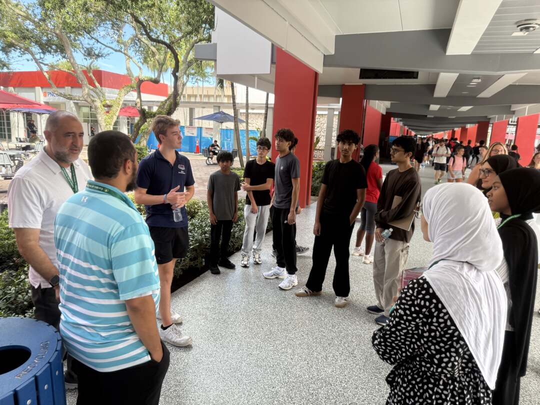 The group gathered with a tour guide along a covered walkway