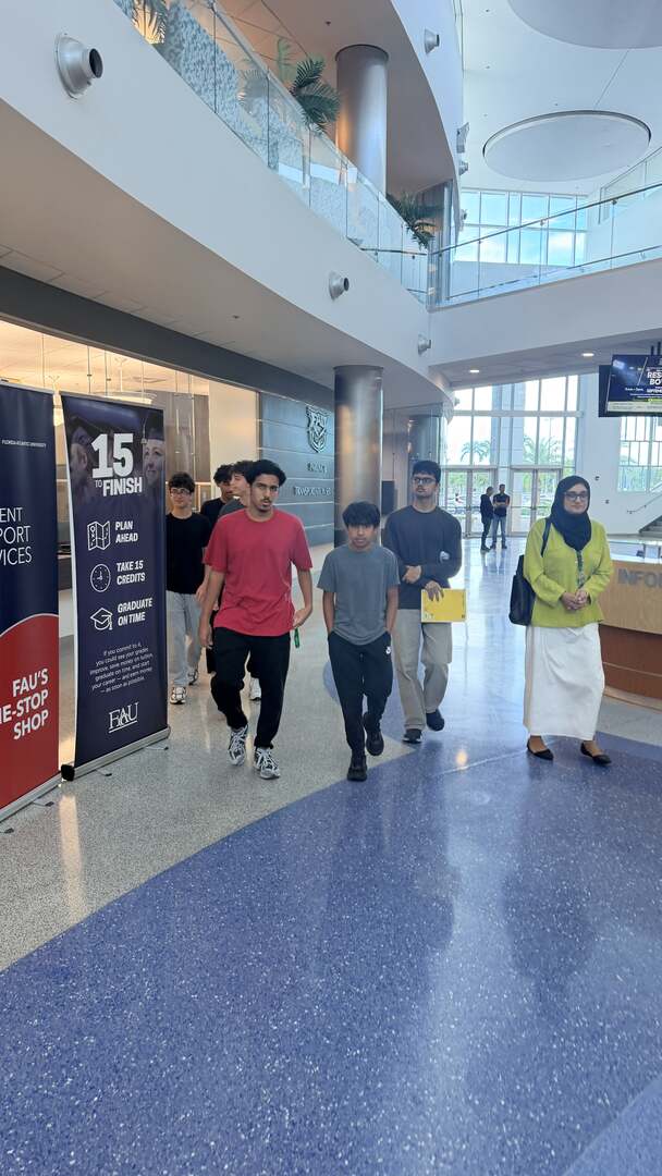 The group walking through a sunlit campus atrium