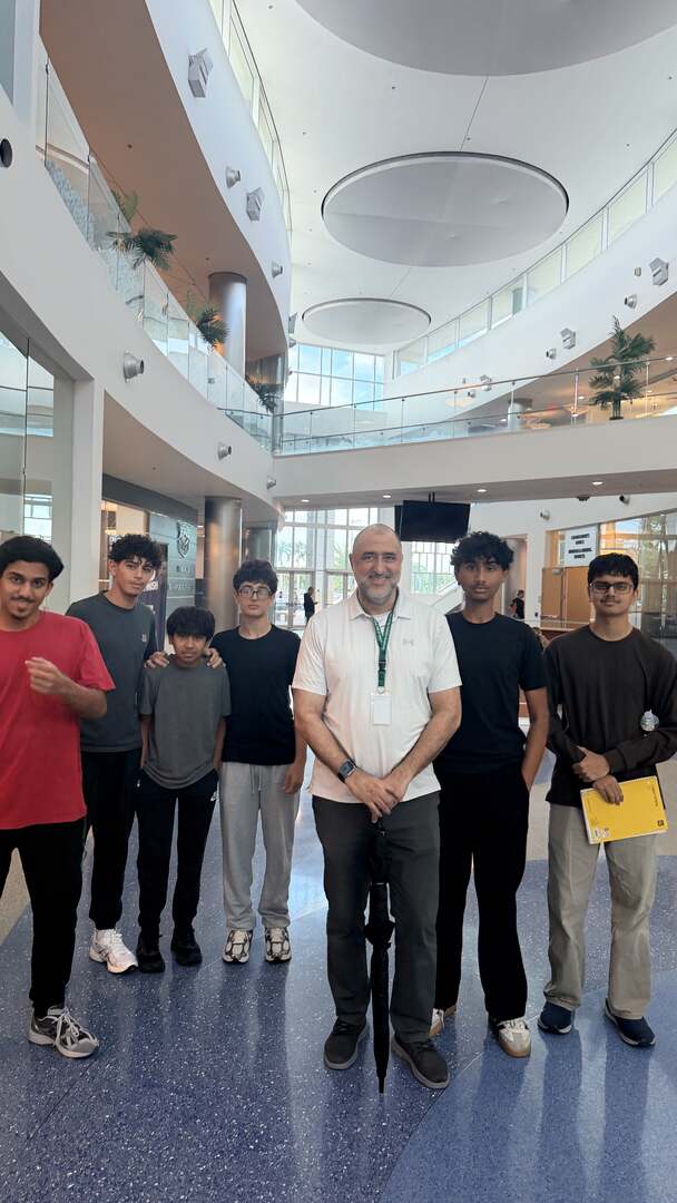 Students and a teacher posing in the open atrium