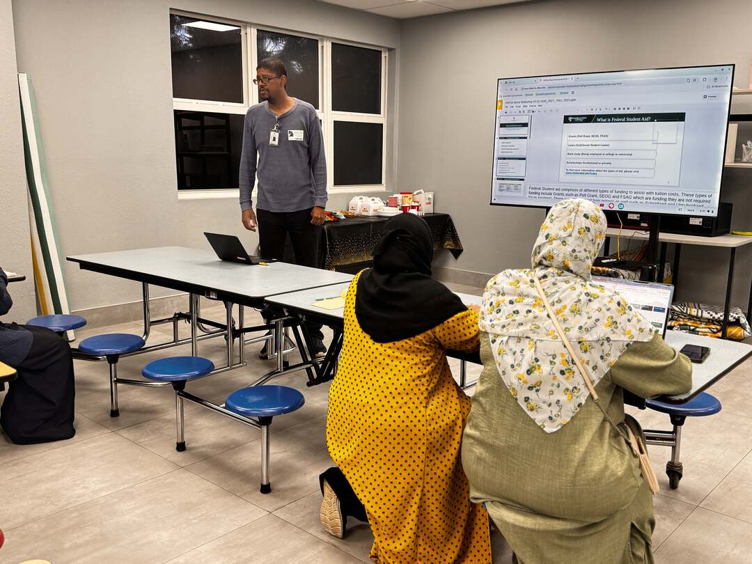 Parents following along as the presenter stands by the slides