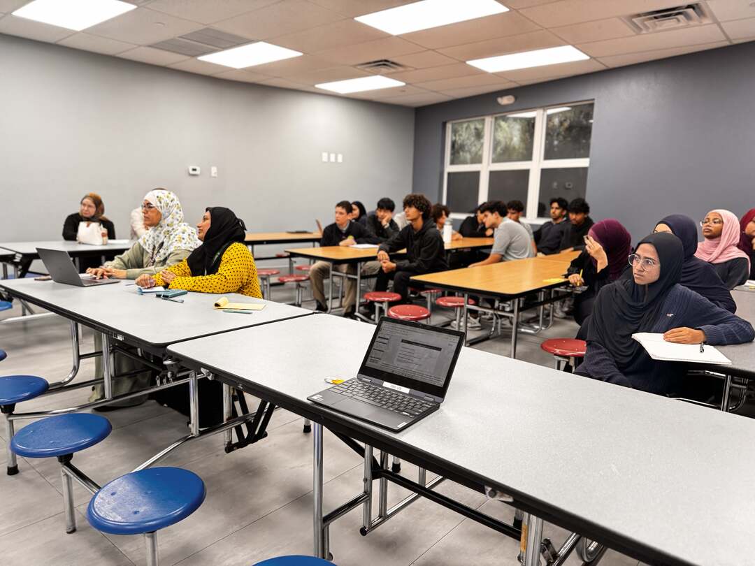 Parents and high school students facing the front of the room