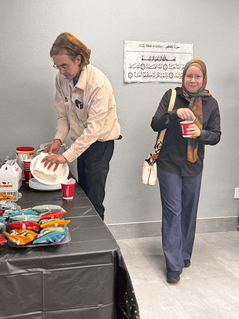 A guest smiling with a cup in hand at the refreshment table