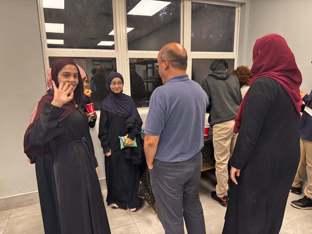 A student waving hello during the social time after the talk