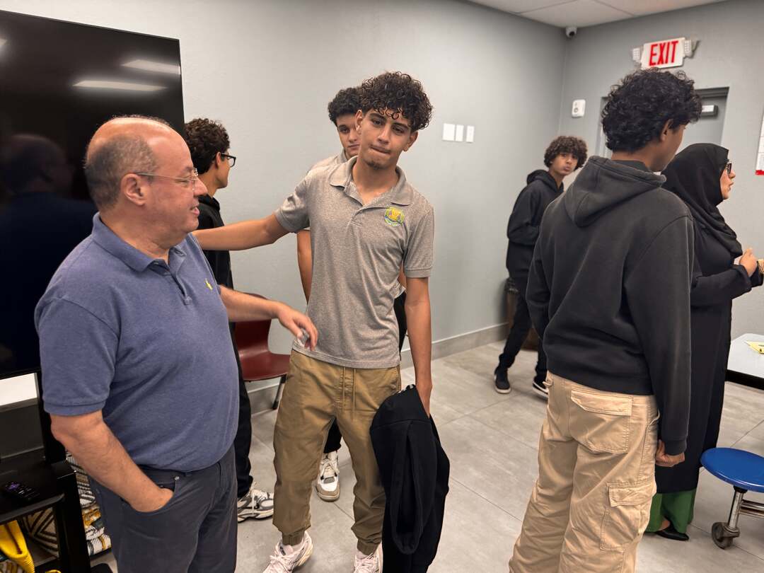 Students chatting with a guest after the presentation