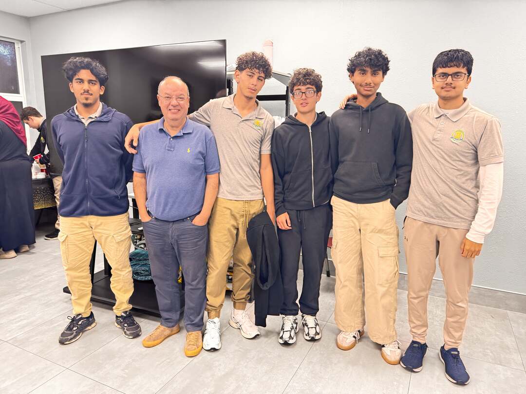 A group of high school students smiling with a guest