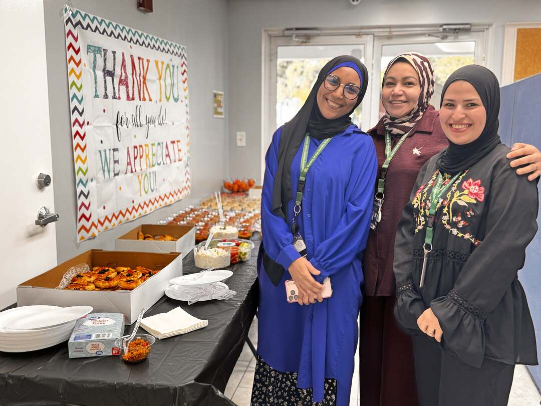 Staff members smiling together beside the breakfast table
